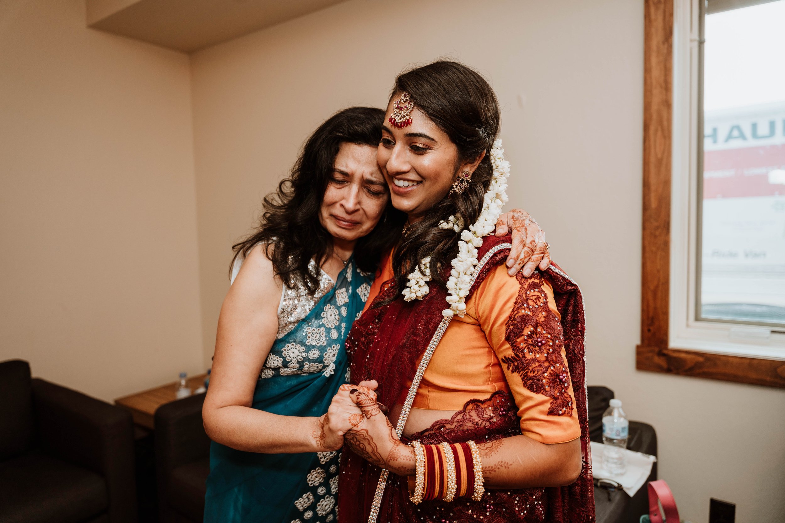 family members help the bride put on the finishing touches