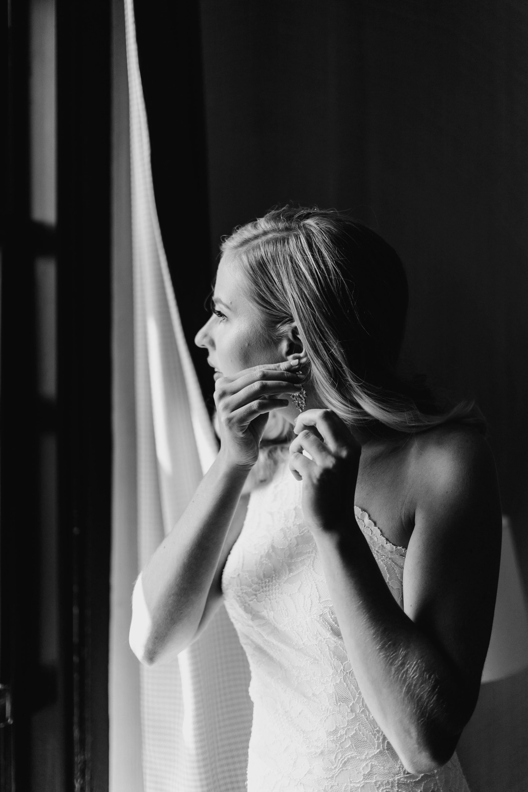 Bride puts in her earrings from Olive & Piper the morning of her wedding