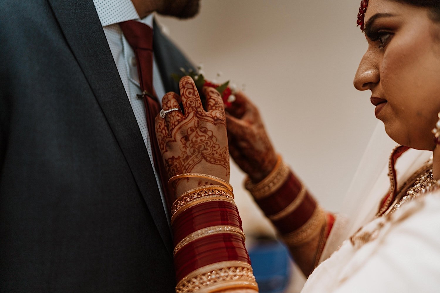 Bride adjusting boutonniere before her Indian Wedding starts