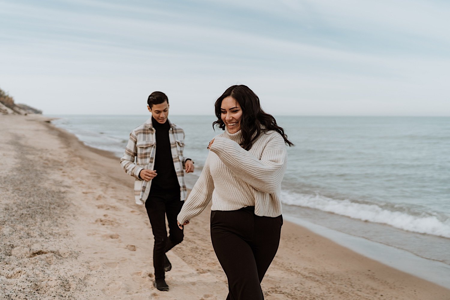 Couple run along beach at Indiana Dunes anniversary session