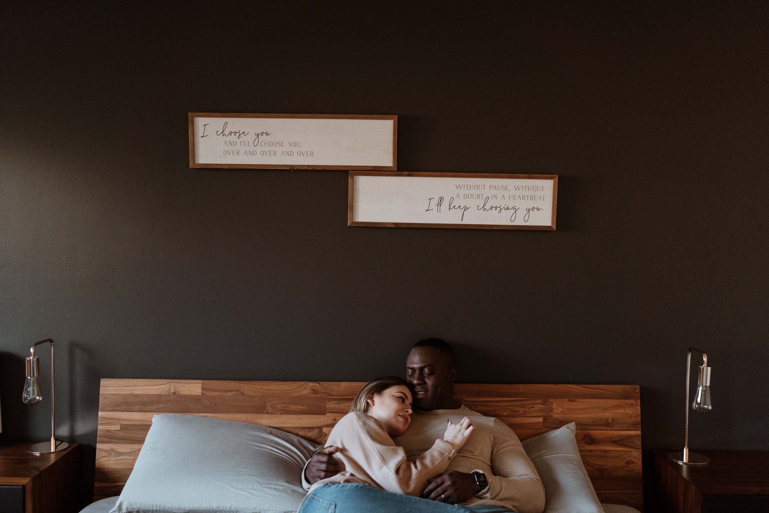 Couple snuggle on bed for indoor photography session