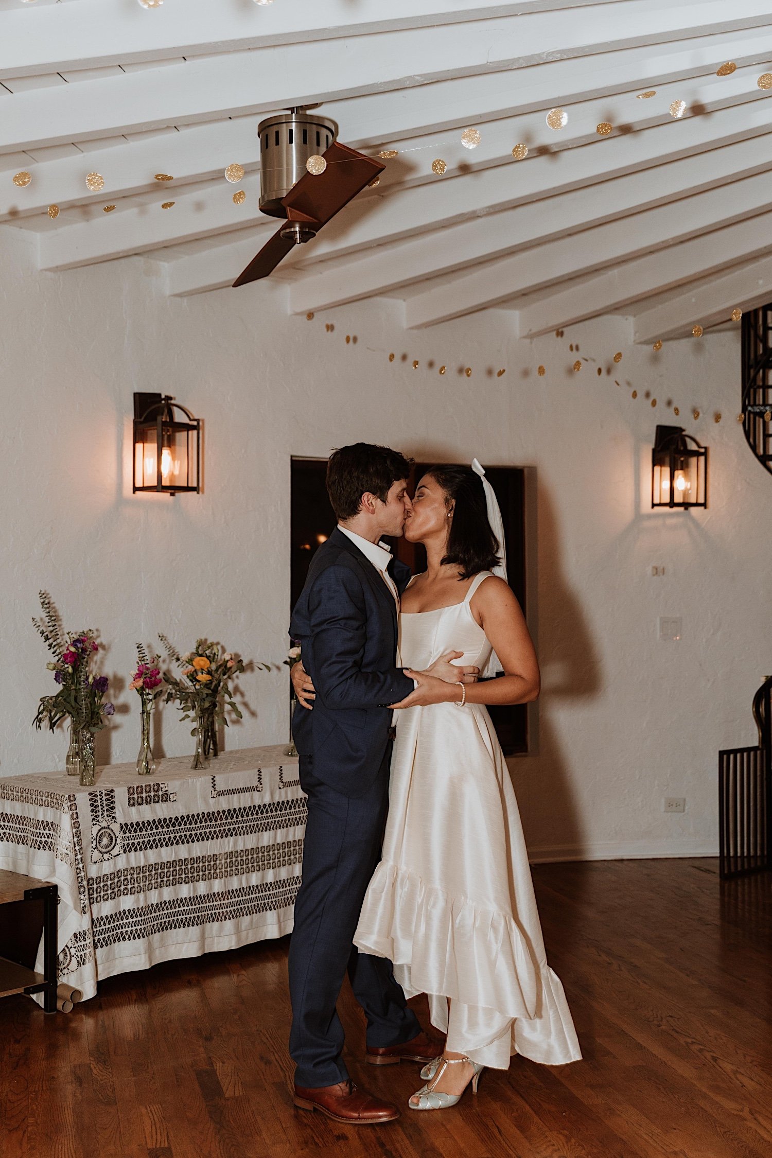 Bride and groom kiss during first dance at intimate Indiana wedding