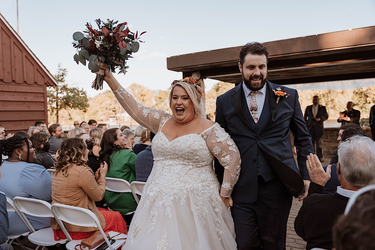 Bride and groom celebrate and walk out from Lake Ellyn Boathouse wedding reception