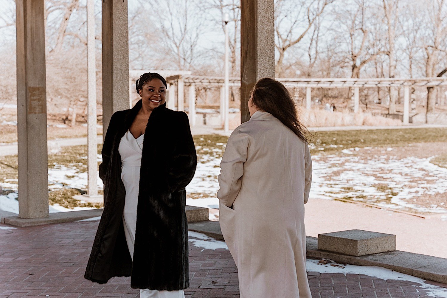 Bride smiles seeing her bride during their first look in the park