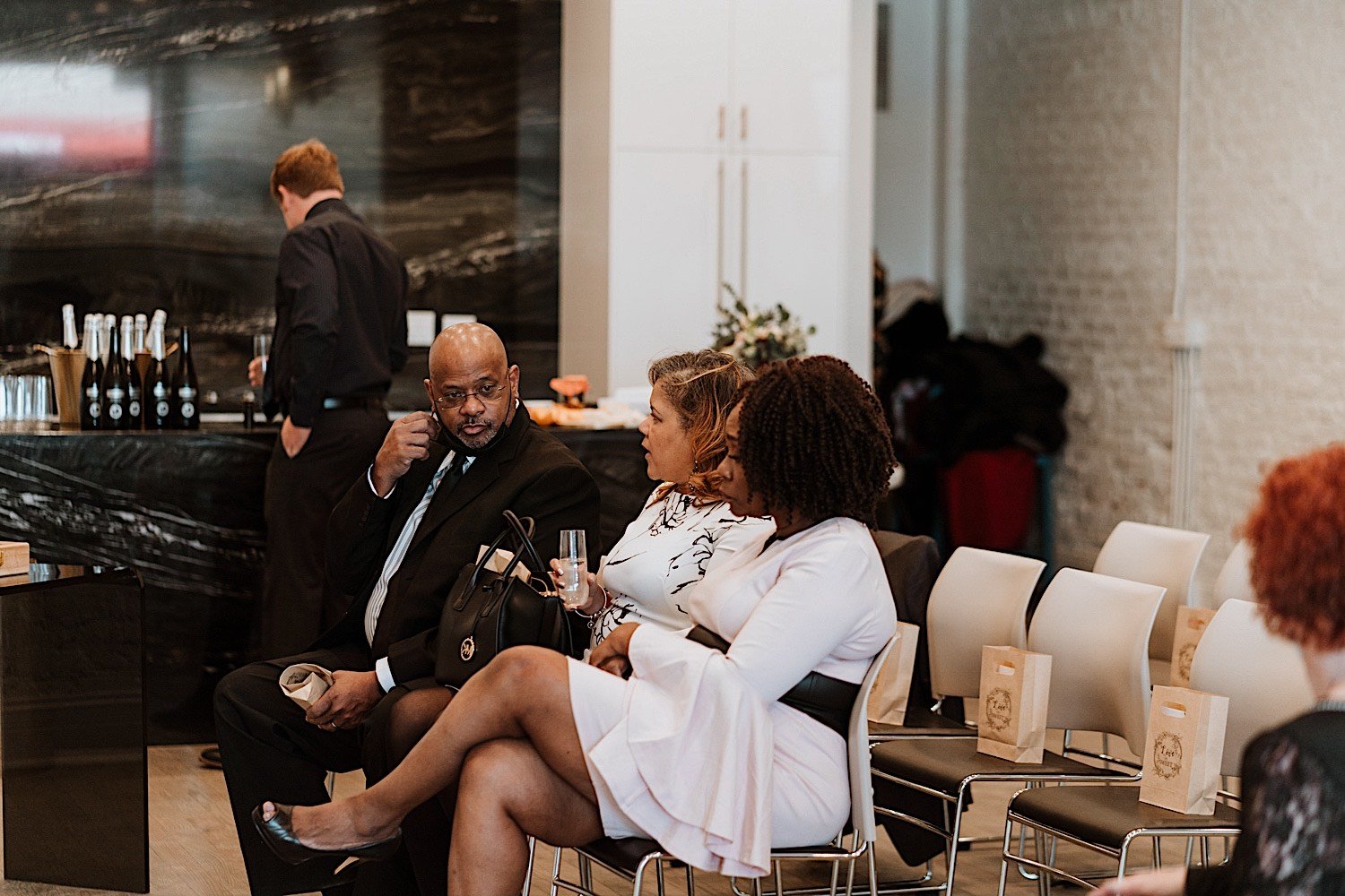 Three guests sit and converse before wedding ceremony