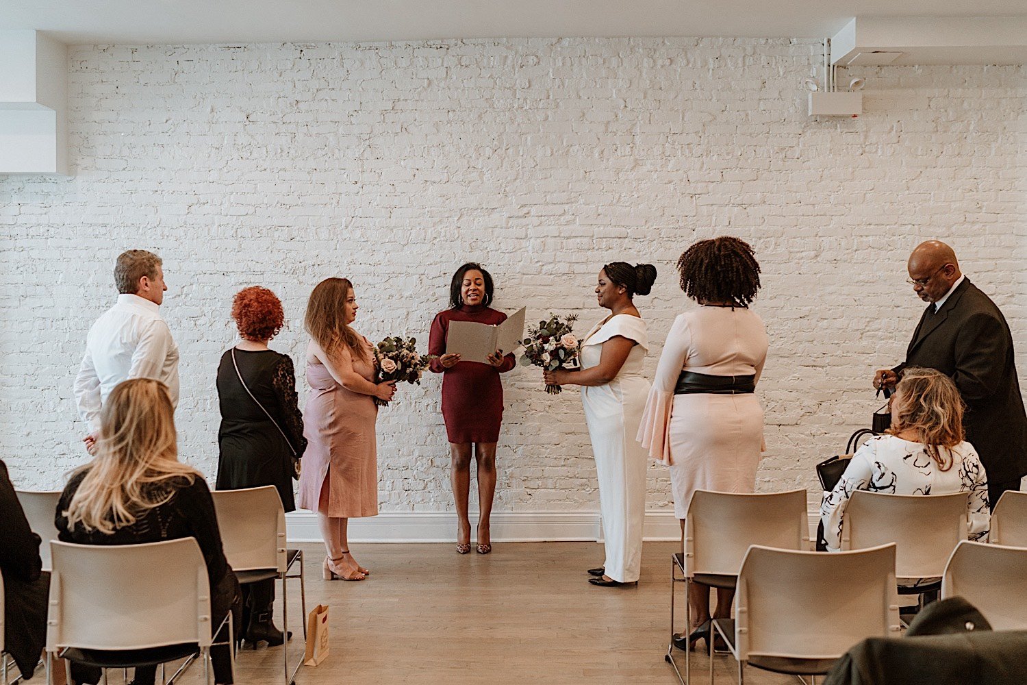Brides being married in their Humboldt Park venue with their parents standing next to them