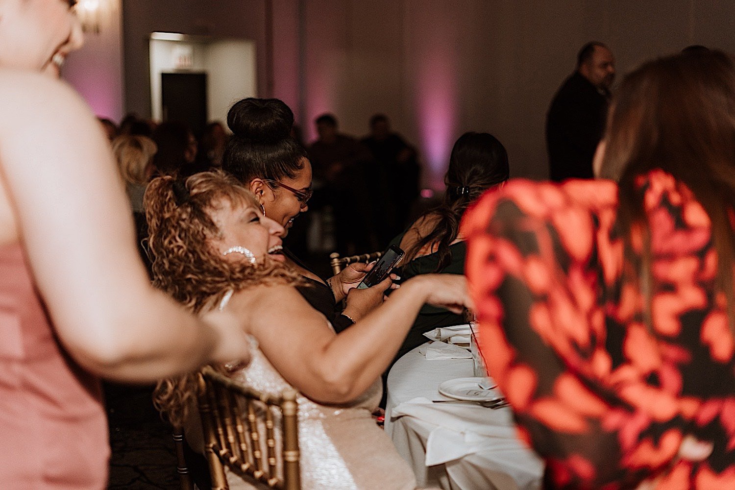 Guests smile and laugh during wedding reception