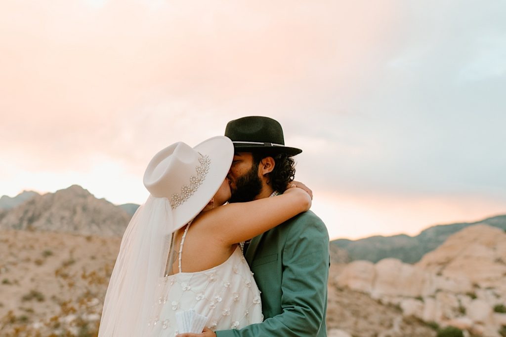 The bride and groom exchanged their vows privately surrounded by the red rocks in Las Vegas while the sun sets