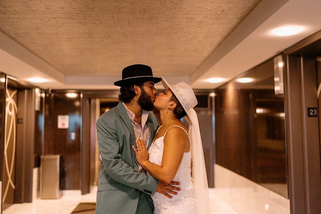 The bride and groom kiss in the elevator at their Las Vegas hotel room.