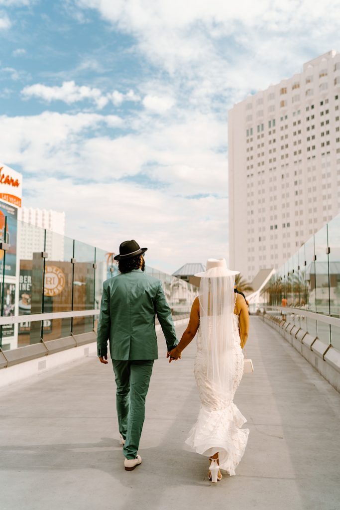 The bride and groom walk across the Las Vegas skybridge to their wedding chapel.