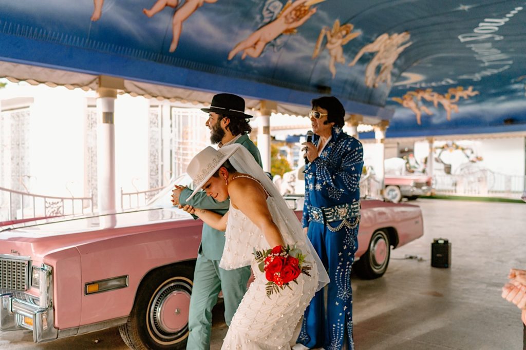The bride and groom dance and celebrate next to Elvis after tying the knot.