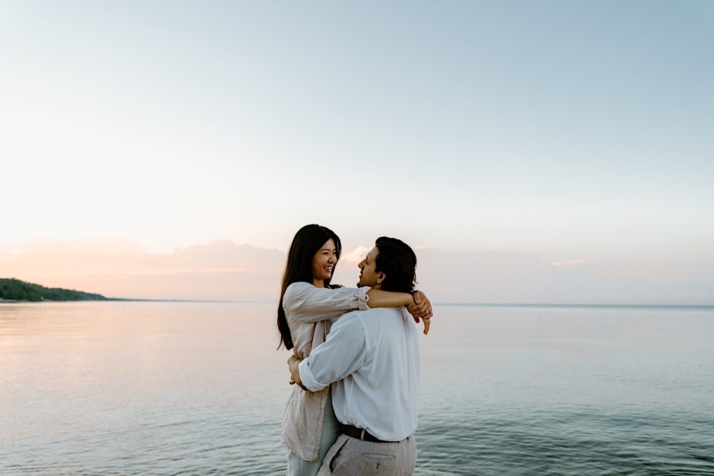 A couple embraces after their Chicago lake front surprise proposal.