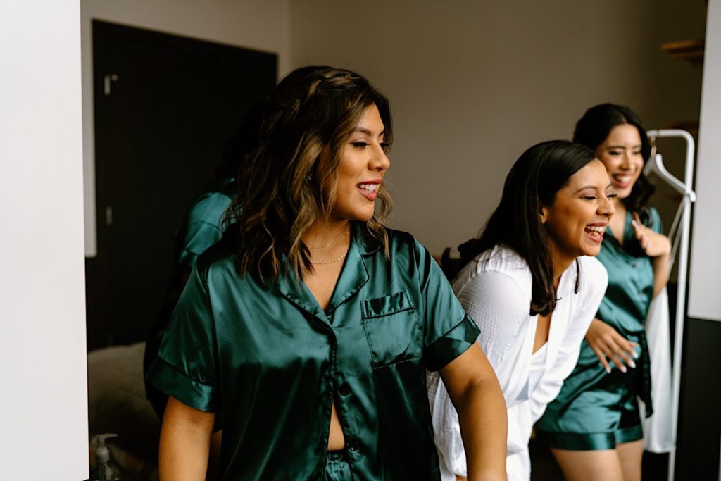 A bride and her wedding party dancing and celebrating their bride the morning of their wedding at their Chicago Airbnb.