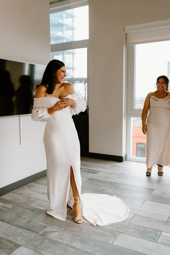 A bride has a first look with her bridesmaids in their Chicago Airbnb.