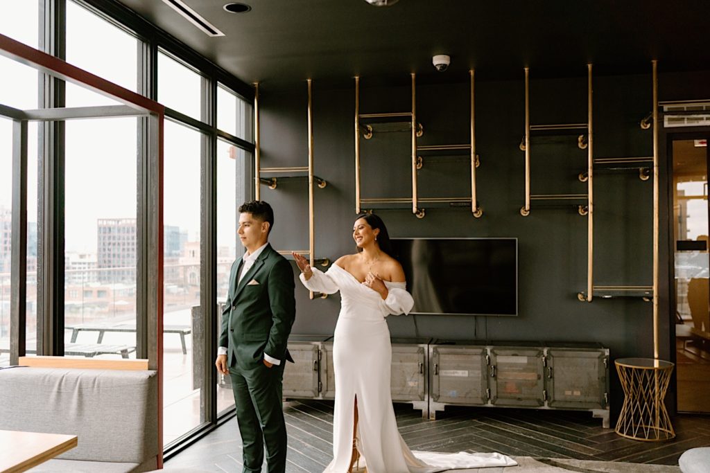 A groom stands and waits for his bride for their first look at their Chicago Airbnb.