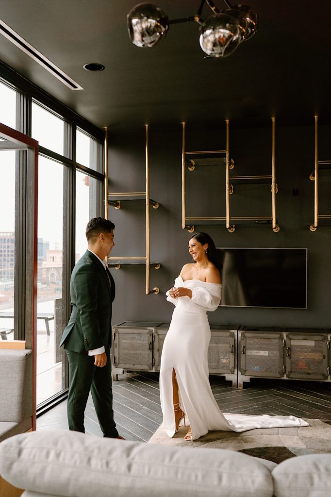 A bride and groom see one another for the first time the morning of their wedding during their first look at a Chicago Airbnb.