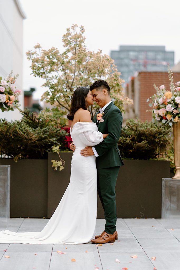 The bride and groom kiss at the end of their ceremony at Loft Lucia surrounded by their loved ones and flowers