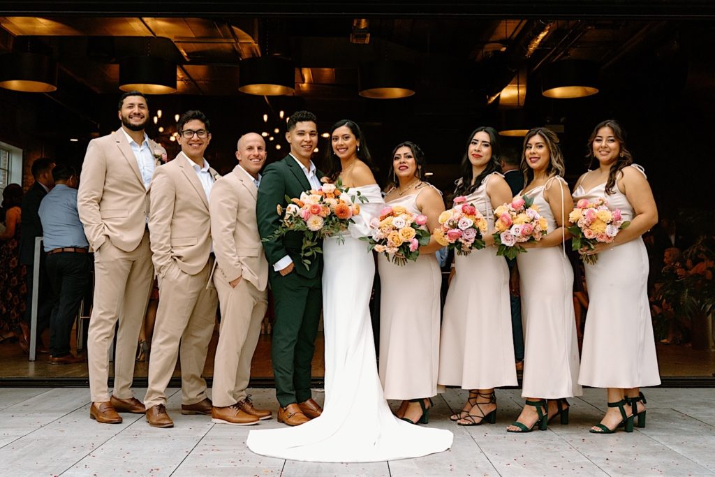 The bride and groom with their wedding party posing for portraits on a Chicago rooftop.