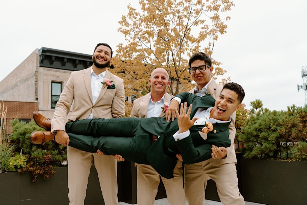 The groom and his wedding party posing for portraits on a Chicago rooftop.