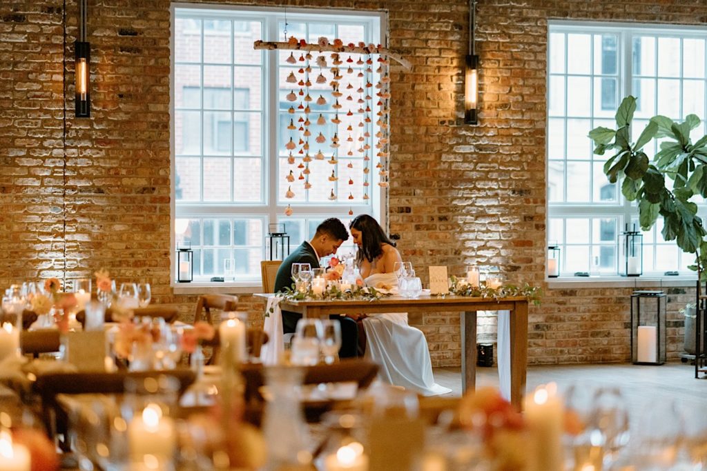 The bride and groom sitting in their ceremony space at Loft Lucia.