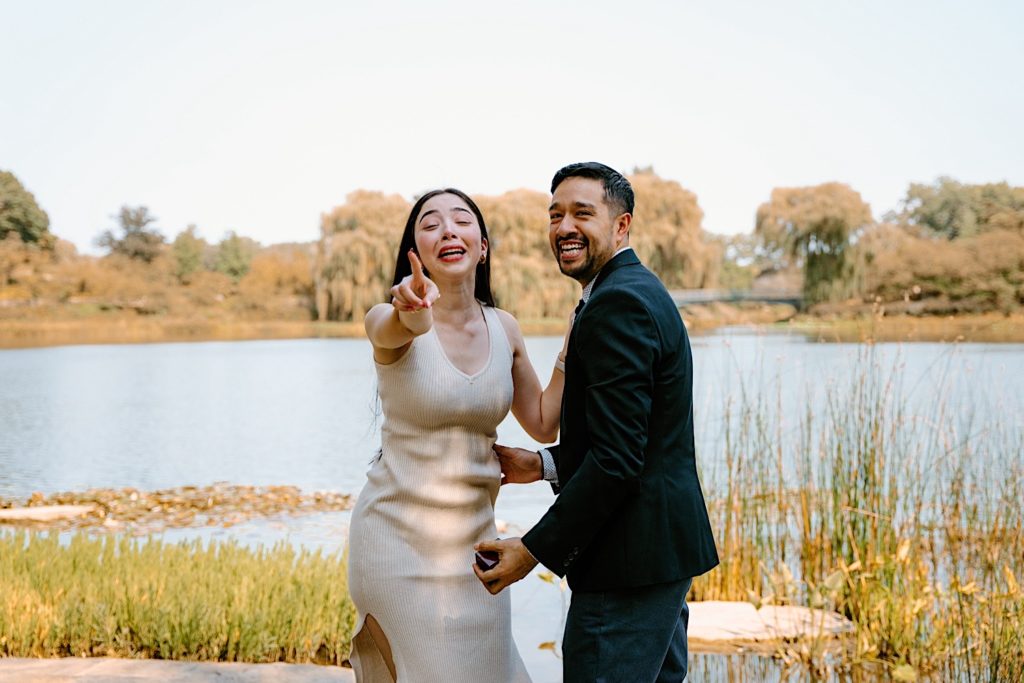 A bride and groom look at the camera  laughing at the photographer 