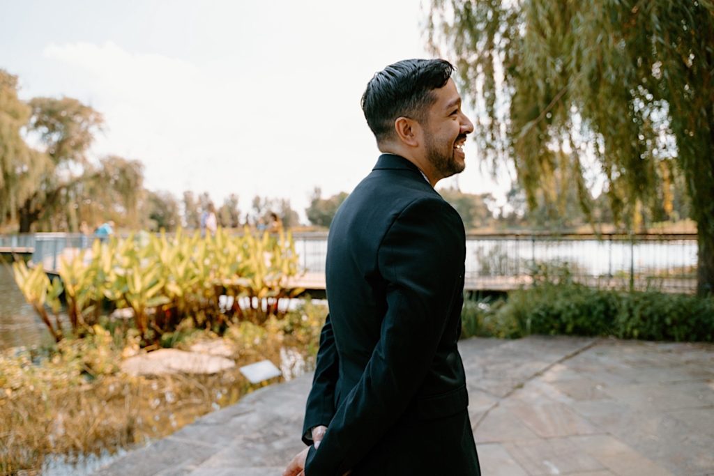 The fiancé smiles and laughs after proposing to his future wife at the Chicago Botanic Gardens