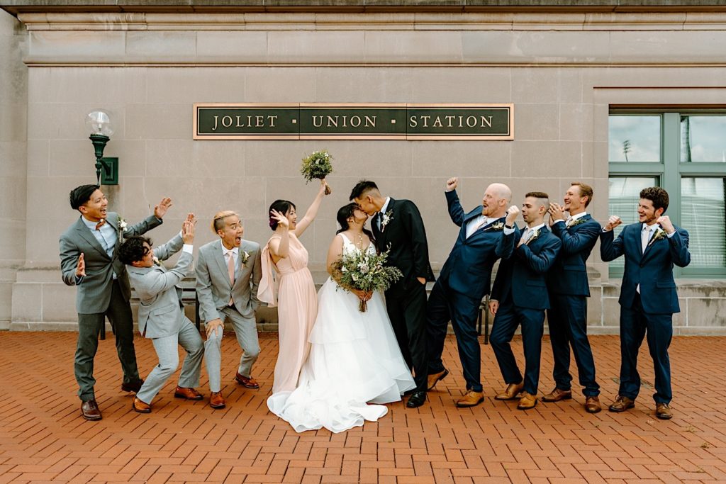 A wedding party stands outside of at Joliet's Union Station posing for portraits.