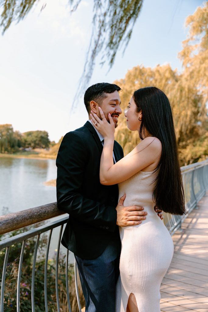 A couple holds one another while kissing on a bridge at the Chicago Botanic Gardens.