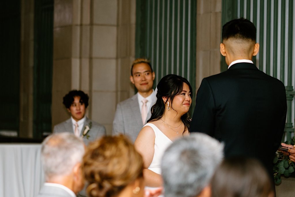 A bride smiles at her officiant during their wedding ceremony at their Joliet Wedding Venue.