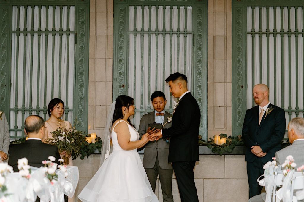 A bride and groom exchange rings during their wedding in Joliet Illinois