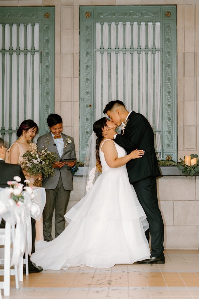 A bride and groom kiss during their ceremony at Joliet Union Station. 