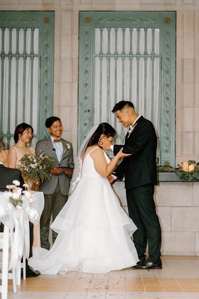 A bride and groom kiss during their ceremony at Joliet Union Station. 