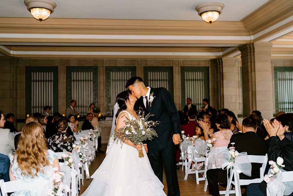 A bride and groom kiss after their wedding ceremony at Joliet Union Station.  