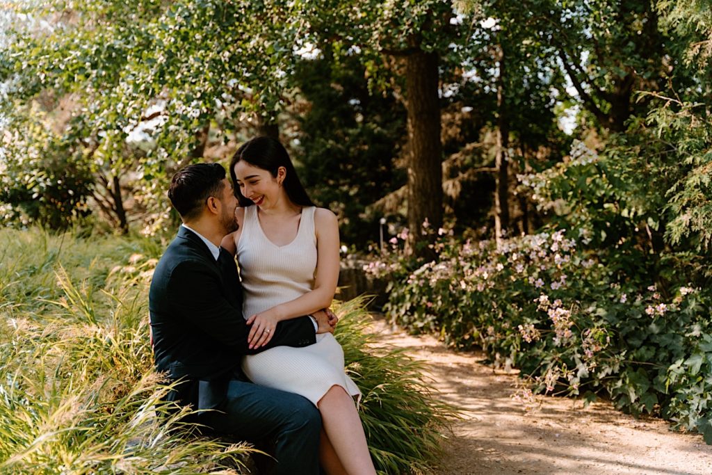 A couple holds one another sitting on a bench at the Chicago Botanic Gardens.