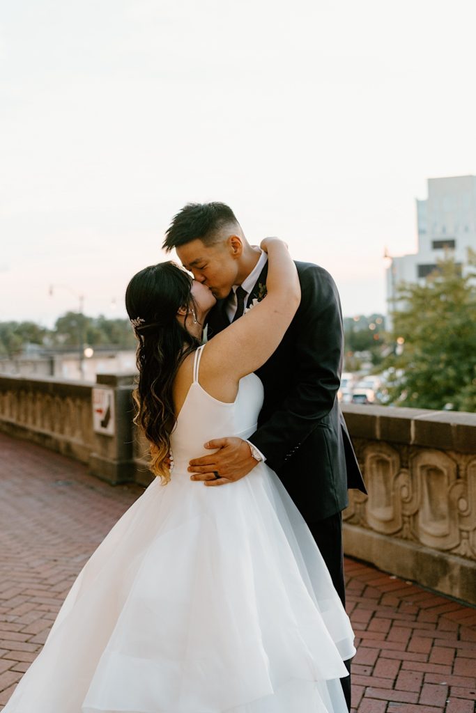 A bride and groom dance while kissing on the balcony at Joliet Union Station. 