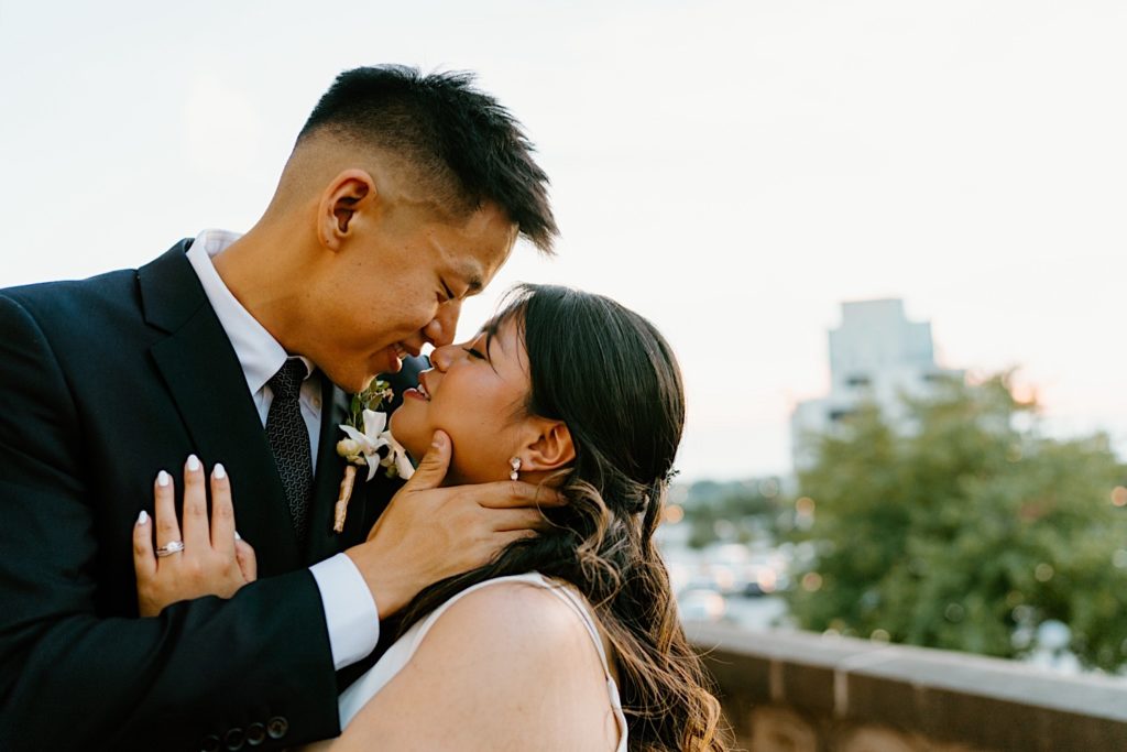 A bride and groom kiss during sunset outside their wedding venue, Joliet Union Station.