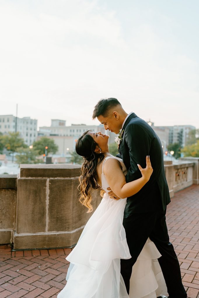 A bride and groom dance while kissing on the balcony at Joliet Union Station. 