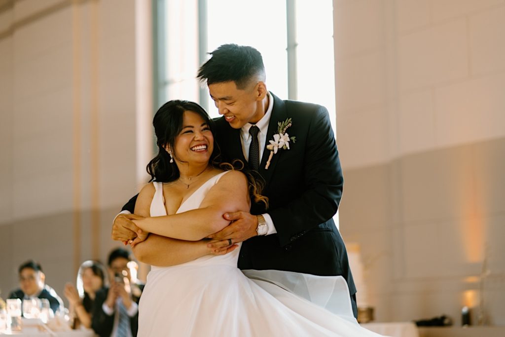 The bride and groom have their first dance at their wedding reception at Joliet Union Station celebrating with their guests.