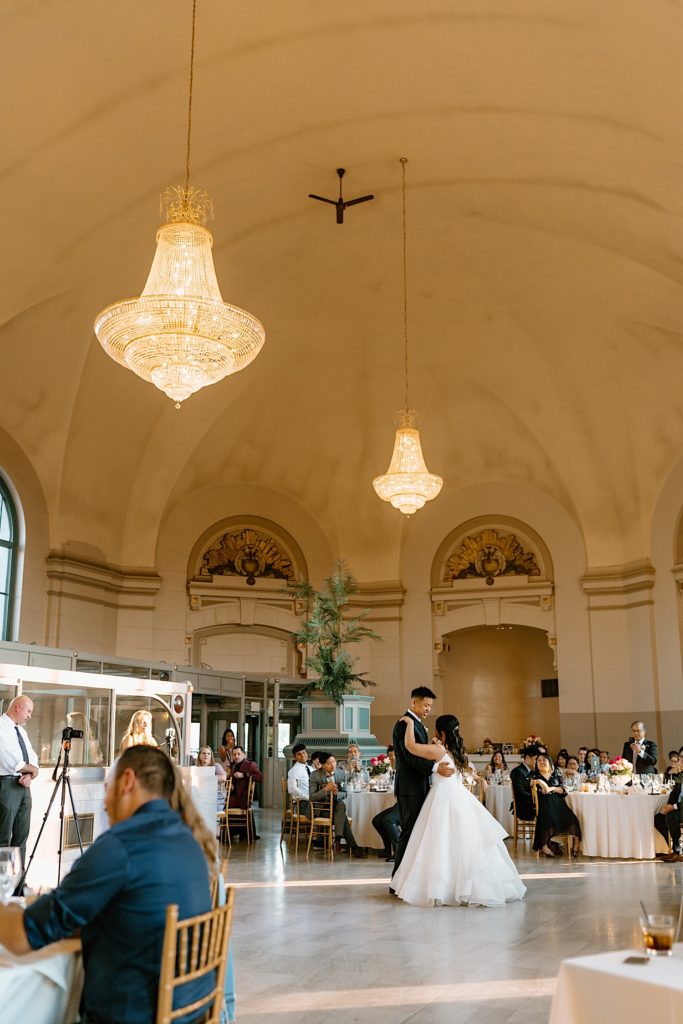 The bride and groom have their first dance at their wedding reception at Joliet Union Station celebrating with their guests.