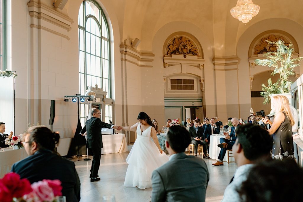 The bride and groom have their first dance at their wedding reception at Joliet Union Station celebrating with their guests.