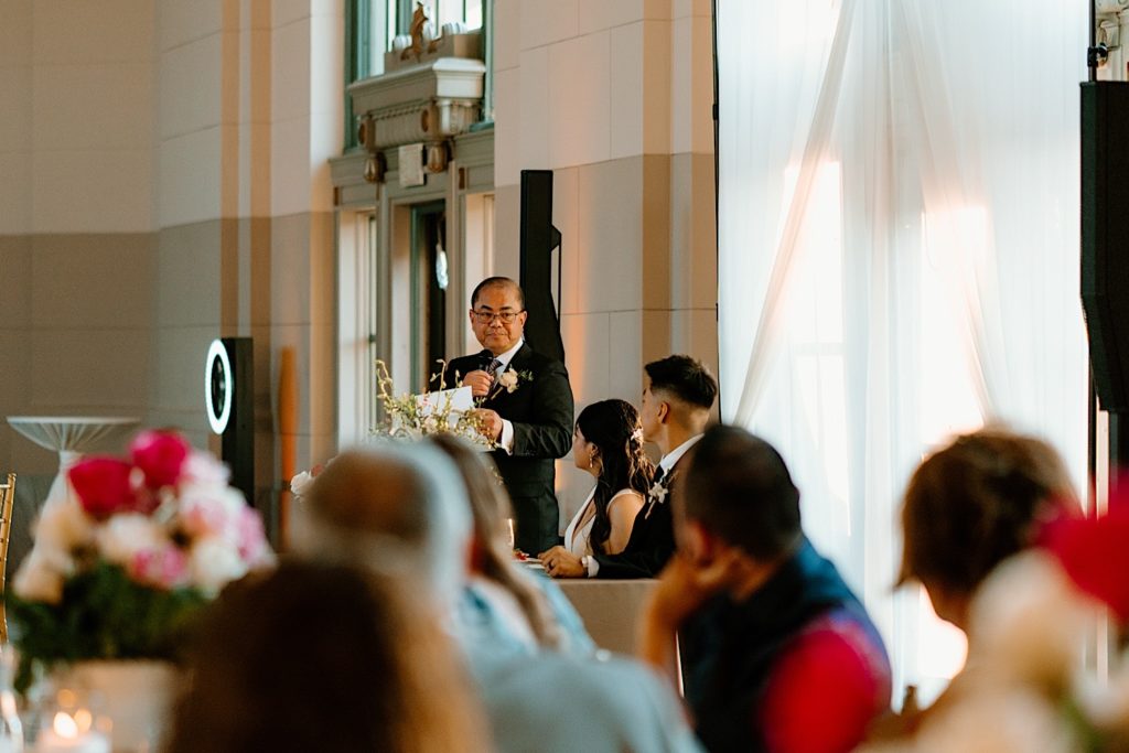 The father of the bride shares a toast with the guests of his daughters wedding.
