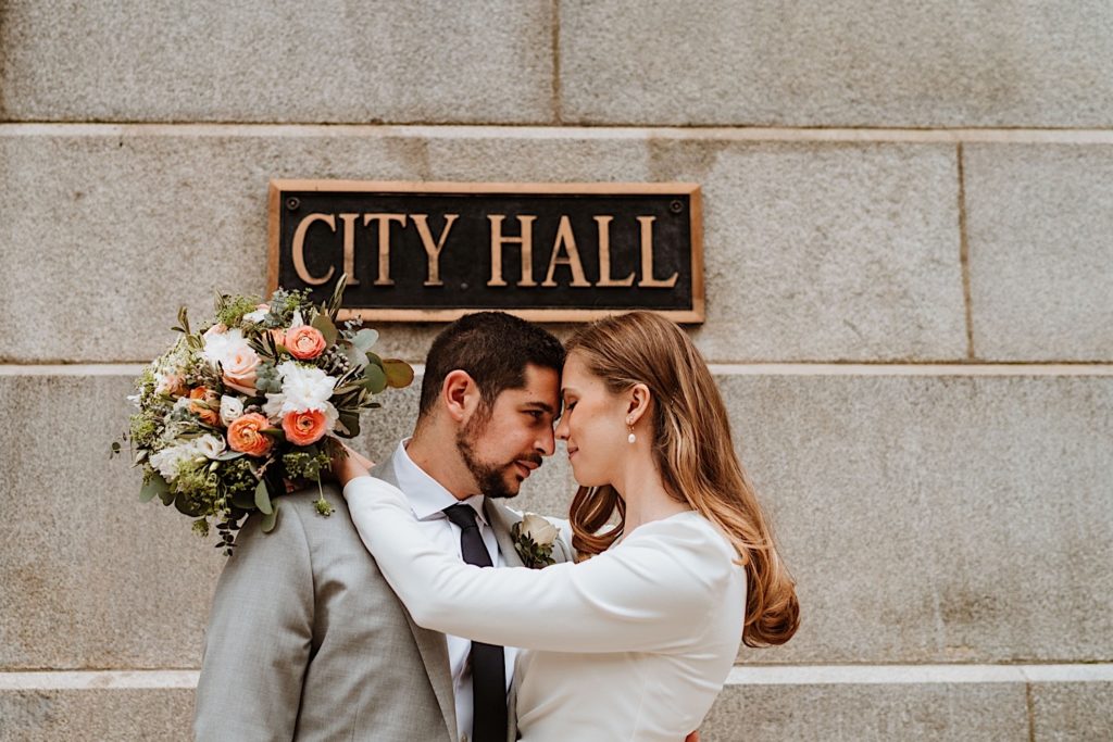 Chicago city hall elopement bride and groom stand in front of the City Hall sign.