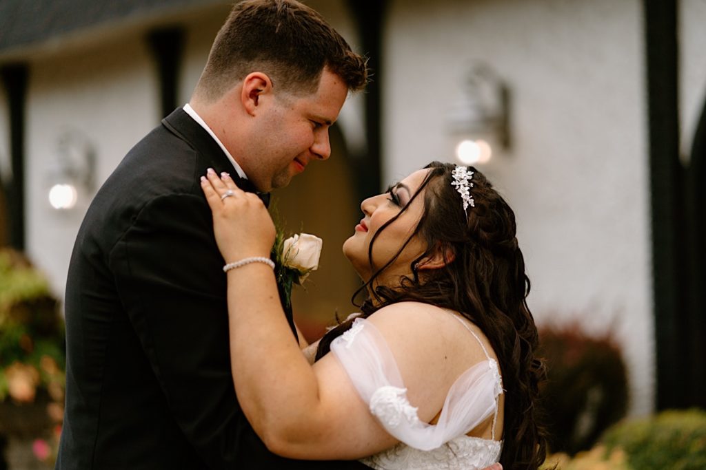 A bride and groom smile at one another during their wedding portraits outside their Chicago wedding venue.