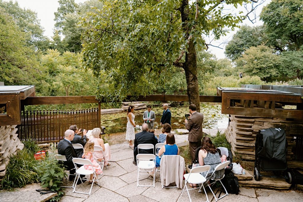 A couples stands facing one another during their Ceremony at Alfred Caldwell Lily Pool.