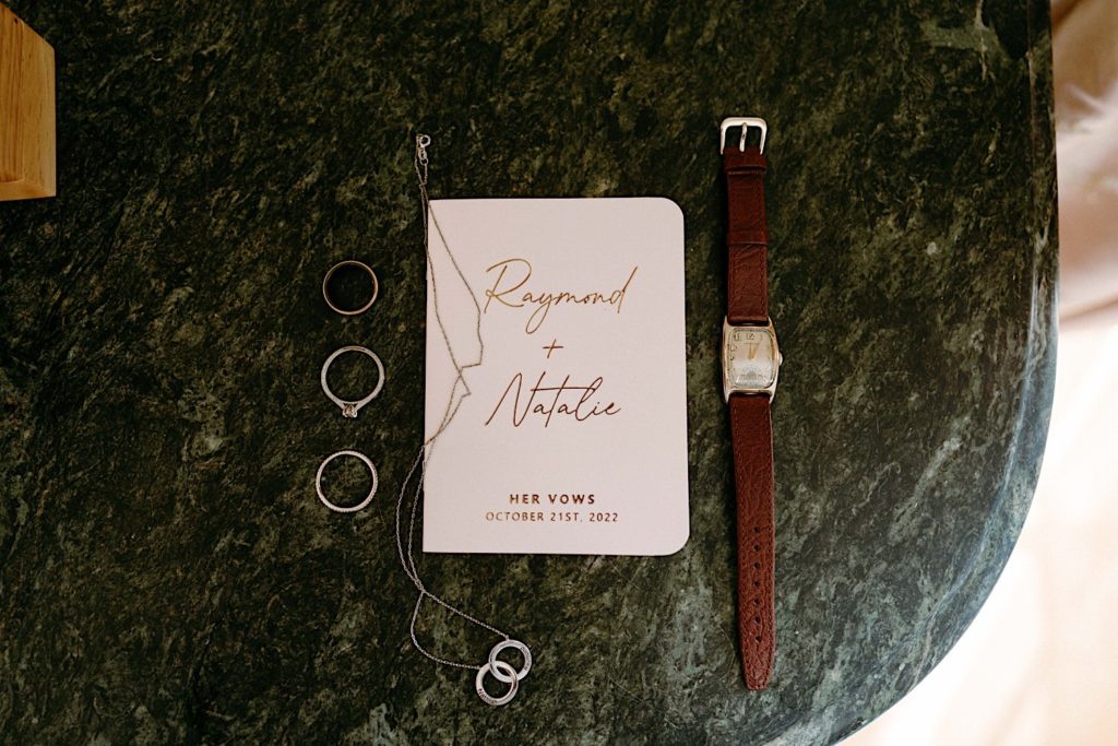 A bride and grooms custom vow book along with their wedding details.