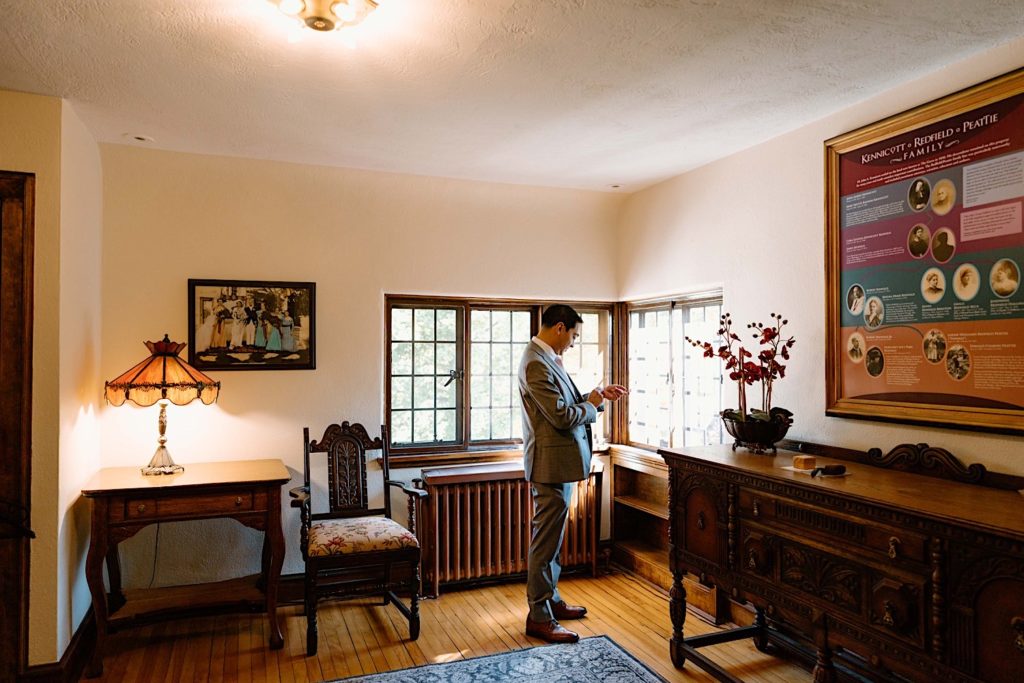 A groom getting ready in the getting ready space of the Grove Redfield Estate.
