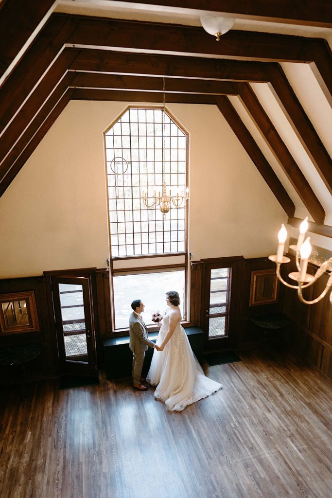 A bride and groom share a first look in the main room of the Grove Redfield Estate.