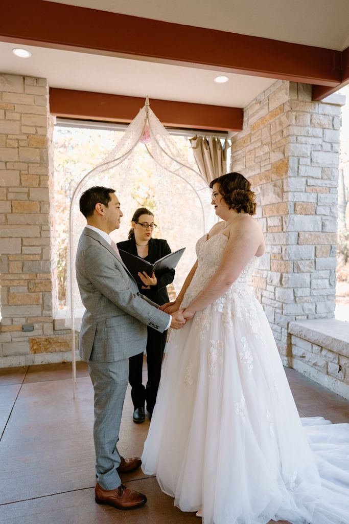 A bride and groom standing at their elopement ceremony at the Grove Redfield Estate.