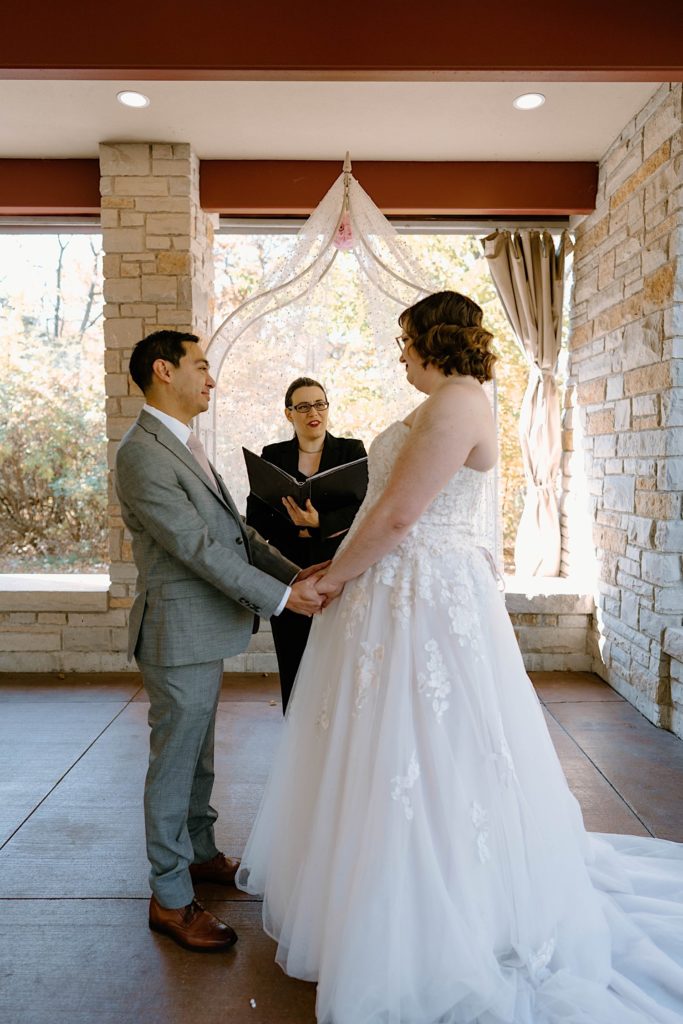 A bride and groom standing at their elopement ceremony at the Grove Redfield Estate.