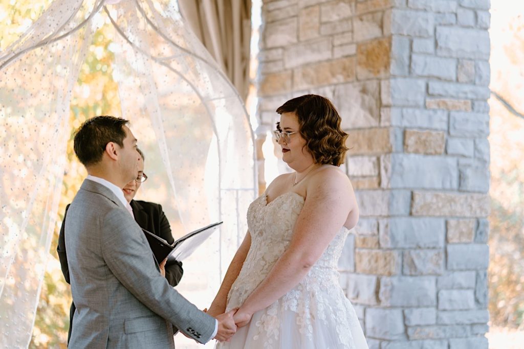 A bride and groom standing at their elopement ceremony at the Grove Redfield Estate.
